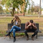 woman-and-man-sitting-on-brown-wooden-bench-984949